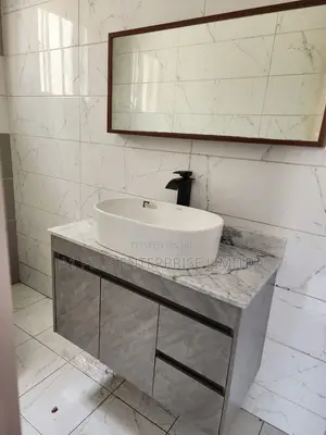Gray Vanity Unit With Sink And Faucet.