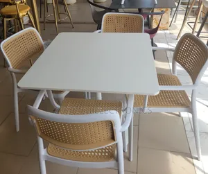 Beige Dining Set With a Square Table and Four Chairs.