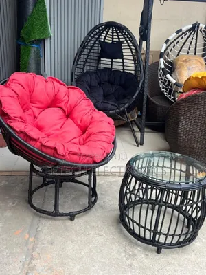 Black Rattan Papasan Chair With a Red Cushion and Table