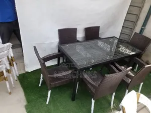 A Synthetic Rattan Outdoor Dining Set With a Glass-Top Table