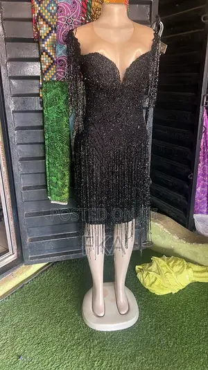 A Fitted Black Knee-Length Dress With a Neckline, Covered in Beads.