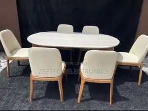 Modern Dining Set Featuring a Sleek Oval Table and Six Cream-Colored