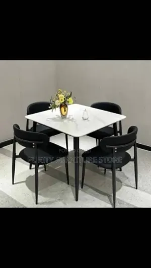 This White Marble-Top Dining Set Features Four Modern Black Chairs