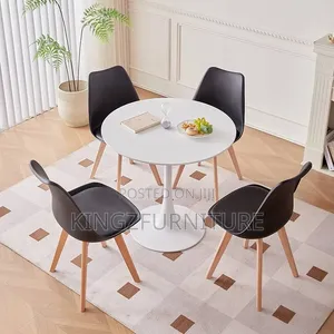 Round White Pedestal Table and Four Matte Black Chairs.