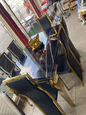 A Six Seater Marble Black Top Dining With Gold Colored Legs