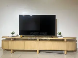 A Long, Rectangular TV Stand With Rounded, Curved Outer Ends.