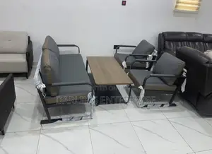 A Metal Frame Sofa With Dark Grey Cushions and a Wooden Coffee Table.