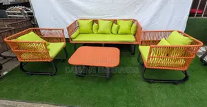 Orange Rattan Sofa Set Features Green Cushions for Outdoor Seating.