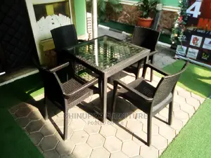 A Set of Plastic Cane Chairs With Glass Top Table